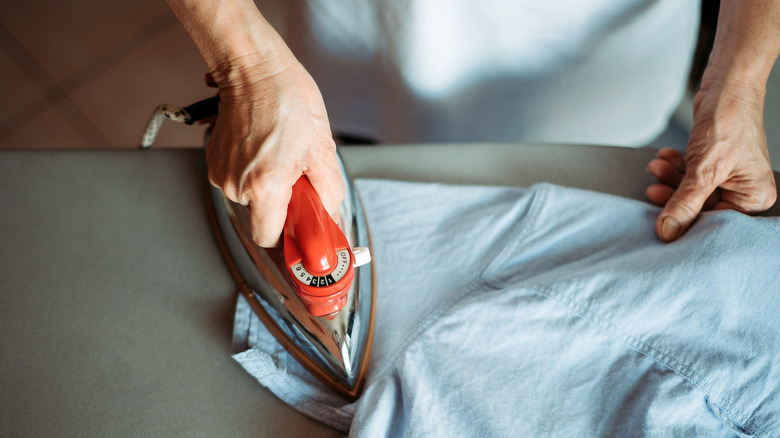 person ironing shirt sleeve