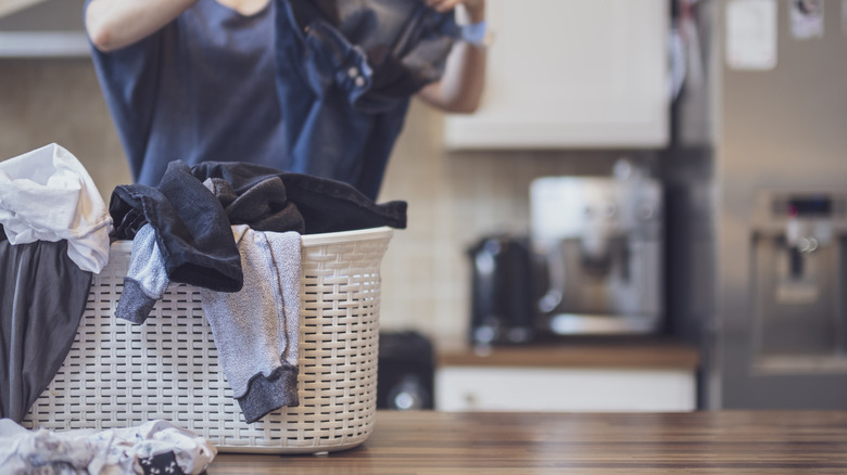 woman folding laundry in kitchen