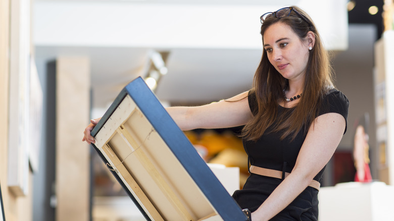 A woman looking at art on a canvas