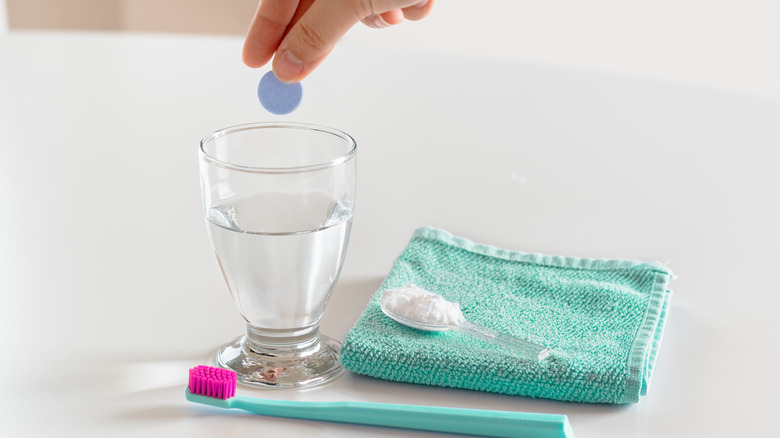 Person dropping denture tablet in water