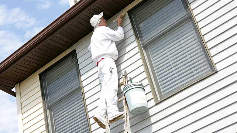 Person on ladder painting house