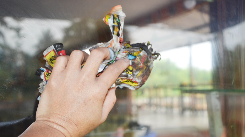 Newspaper being used to clean glass