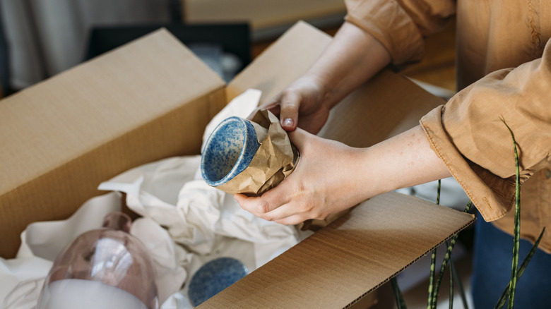 Woman holding mug wrapped in packing paper