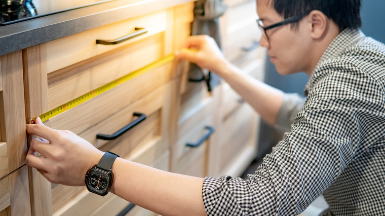 man measuring a kitchen drawer