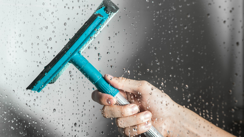 hand squeegeeing glass shower door