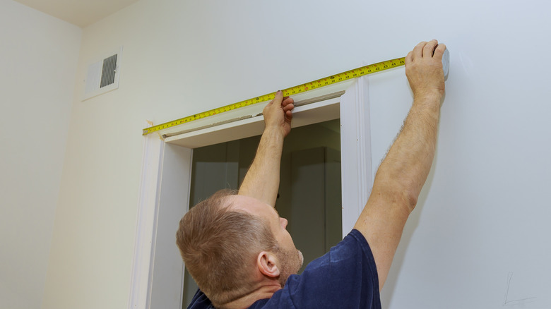 Man measuring door frame