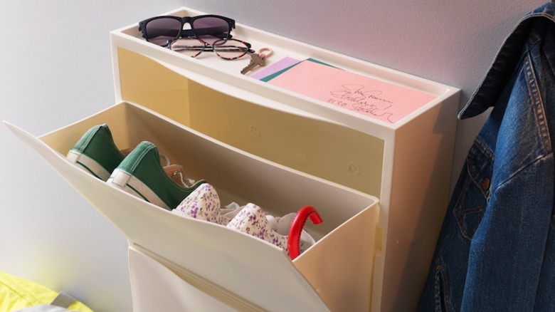 Shoes inside of IKEA TRONES cabinet attached to interior wall