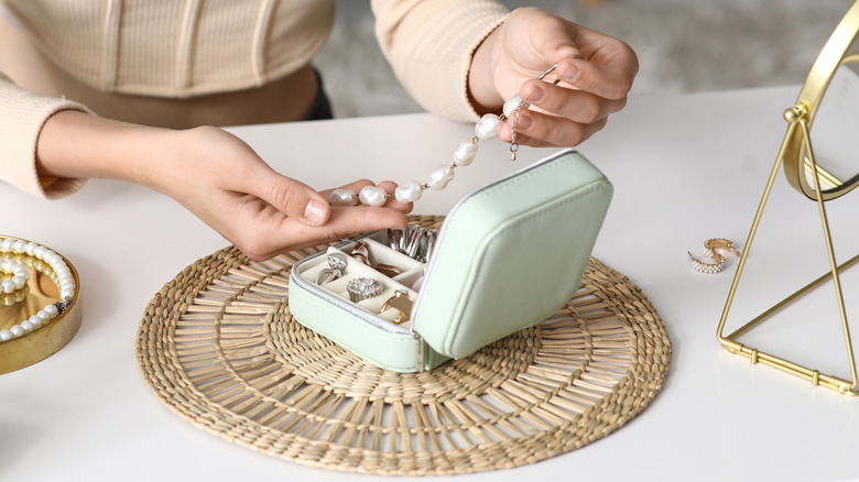 Women going through her jewelry box at home