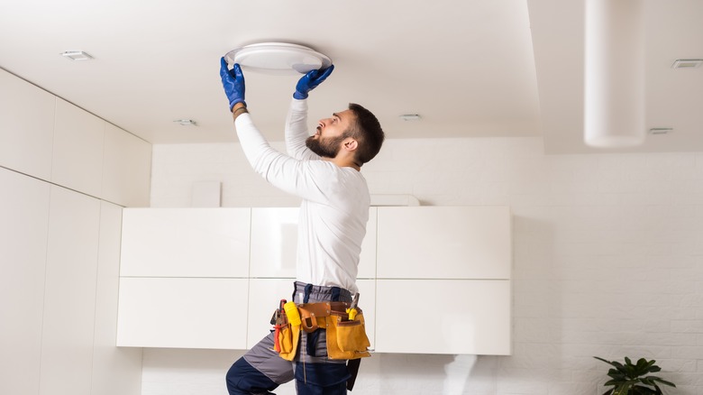 man installing ceiling light