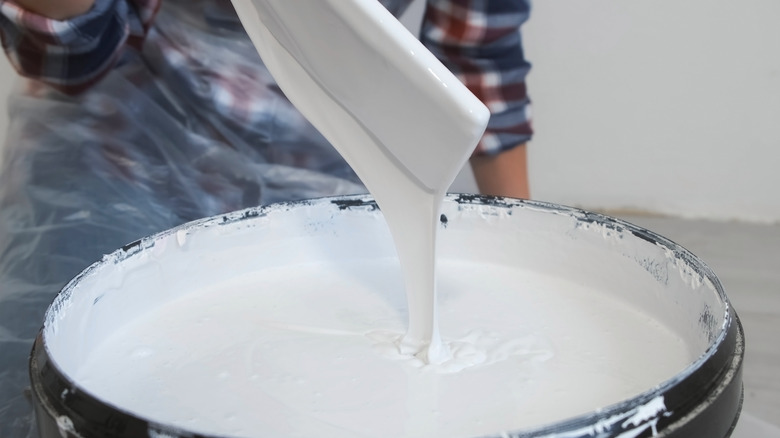 Wooden stick being used to stir paint