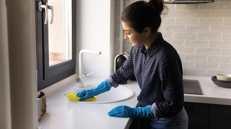 Woman wiping down kitchen counter