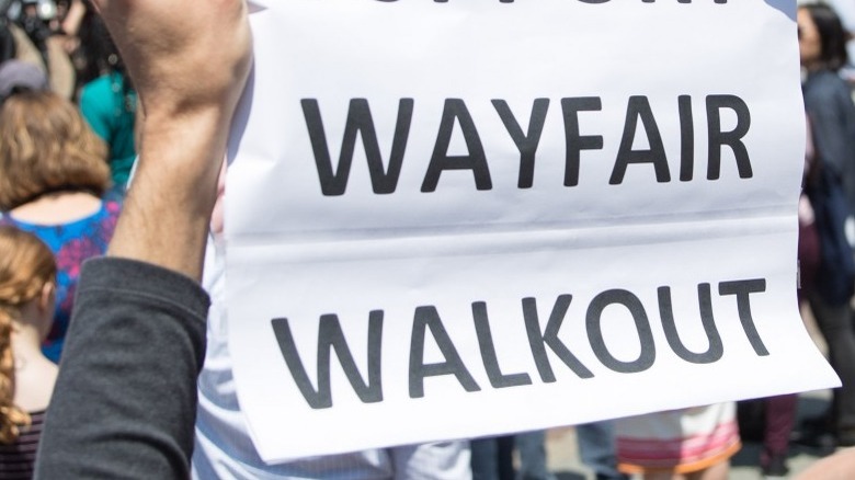 Protesting Wayfair employees hold sign 