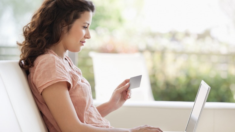 Woman shopping online holding credit card