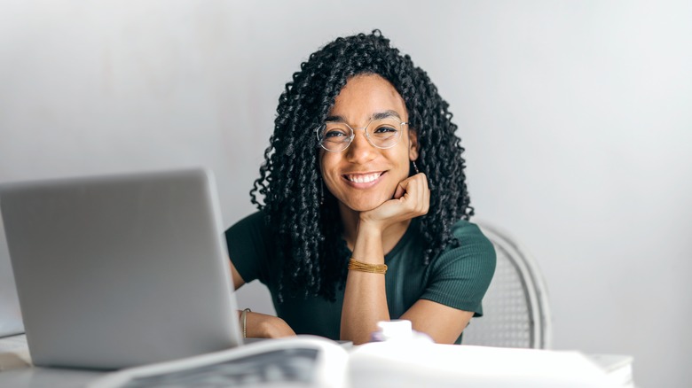 Woman smiling next to laptop