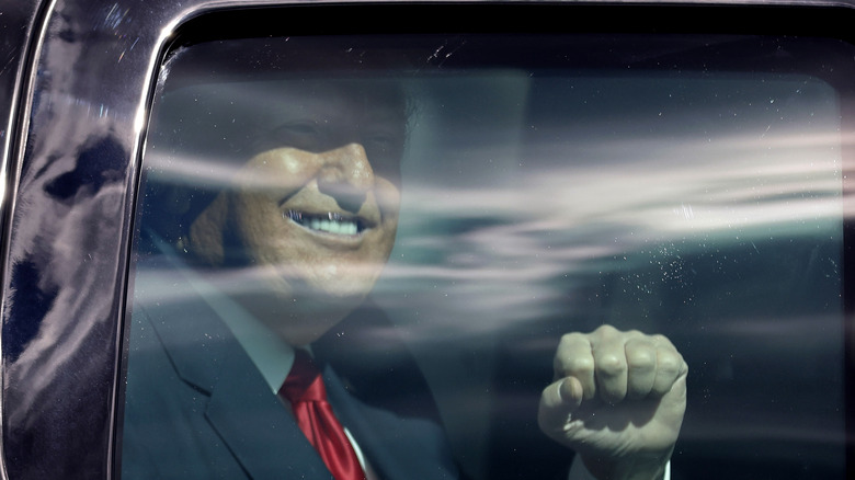 Donald Trump raising his fist in a limo 