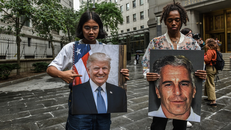 Two women holding pictures of Jeffrey Epstein and Donald Trump 