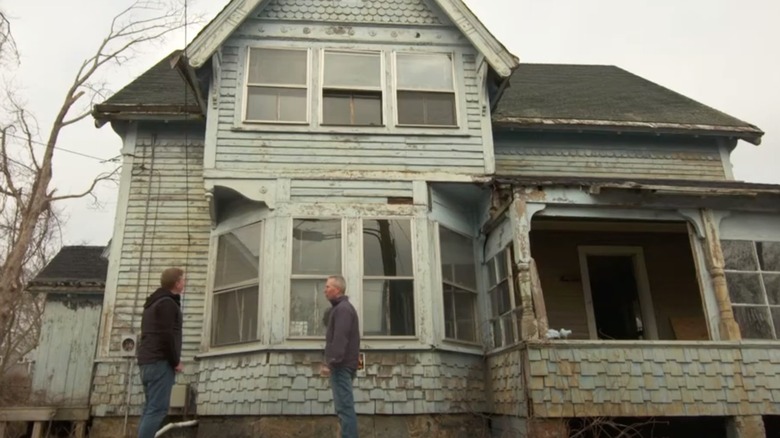 men in front of old house