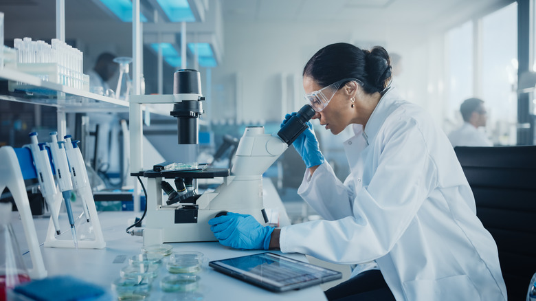 female lab scientist with microscope 