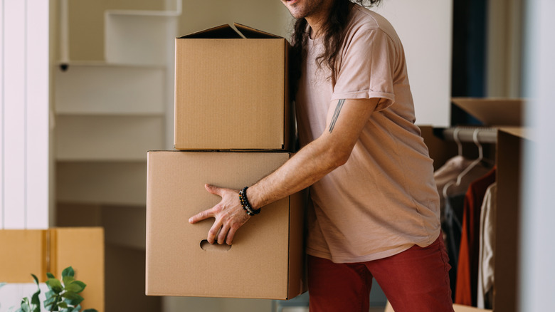 A person juggles two cardboard boxes