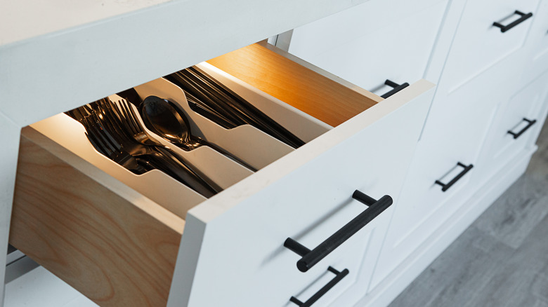 A white open kitchen drawer with lights.