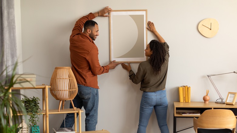 couple putting up art