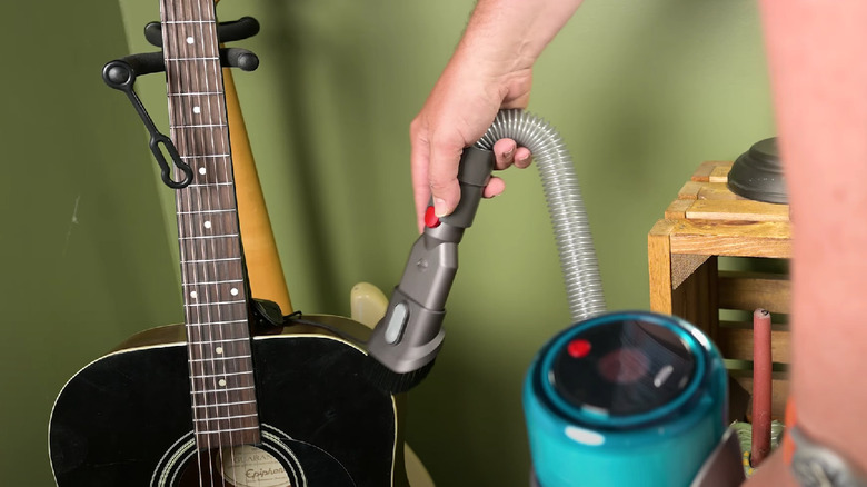 vacuuming guitar with hose attachment 