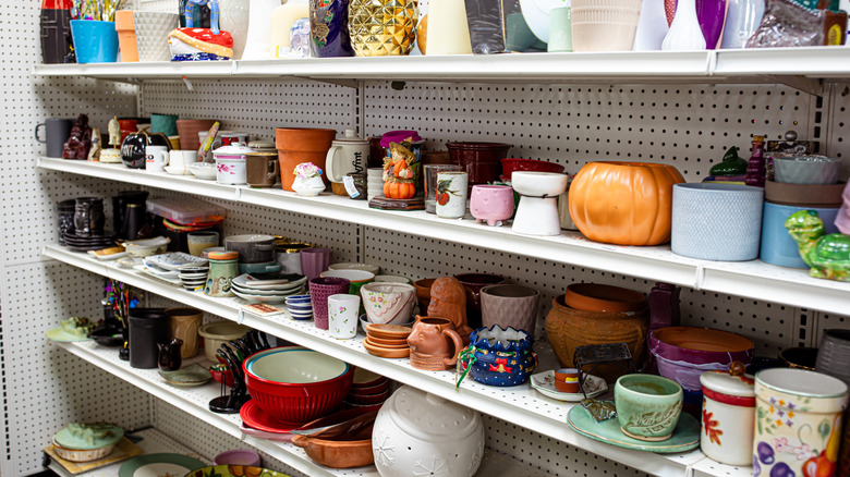 Shelves showcasing plates and other dinnerwares inside a thriftstore