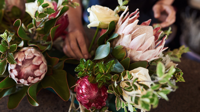 Hands arranging flowers on a table