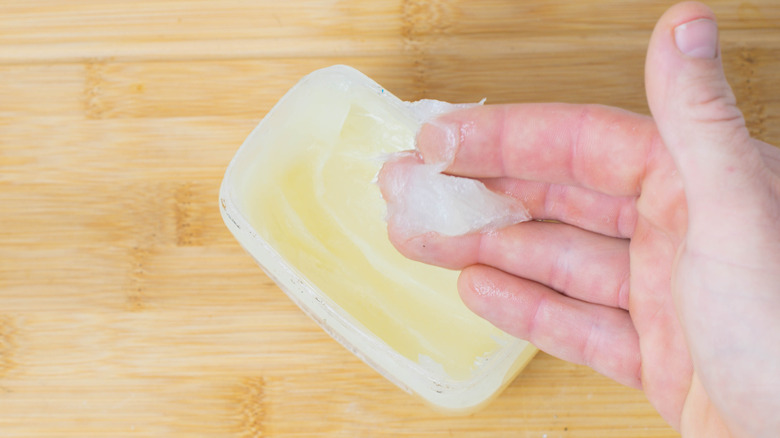 dipping finger in Vaseline jar