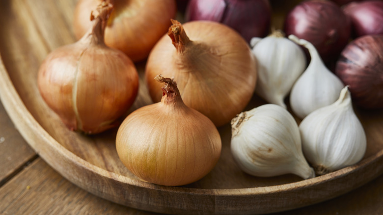 Assorted onions on wooden bowl