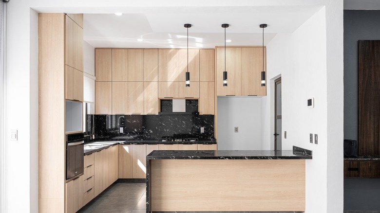 a neutral modern kitchen with light maple wood cabinetry