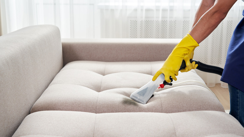 person using couch deep cleaner