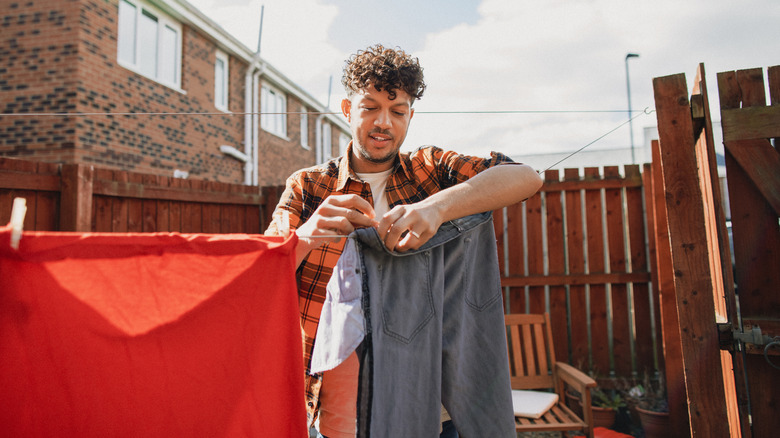 Man hanging clothes on clothesline