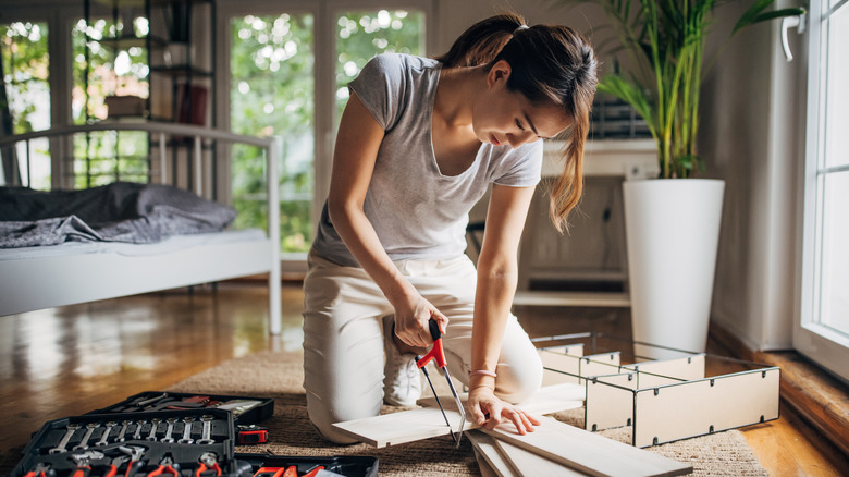 Woman cutting wood with saw