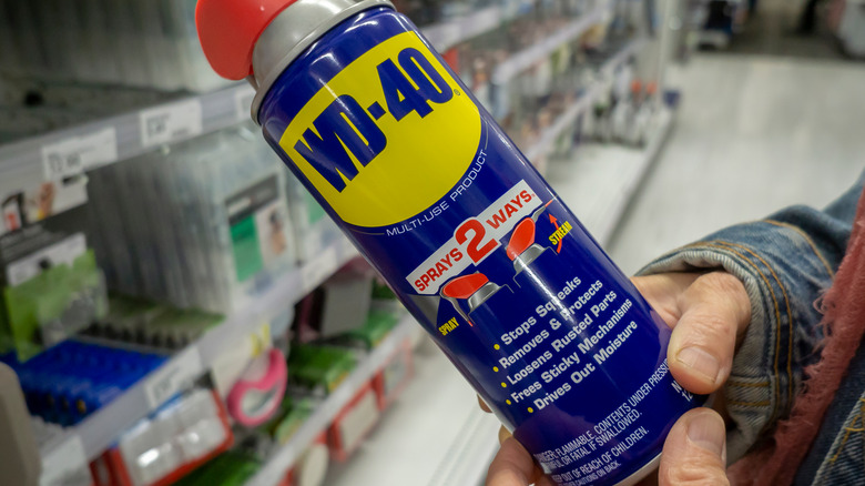 man holds WD-40 can