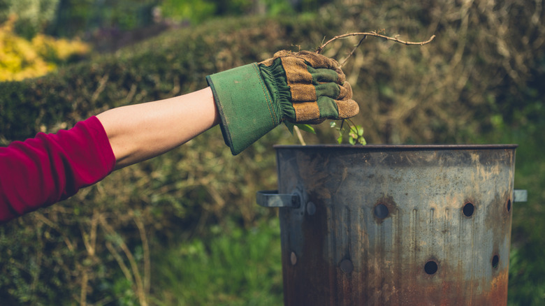 woman putting weeds in incinerator