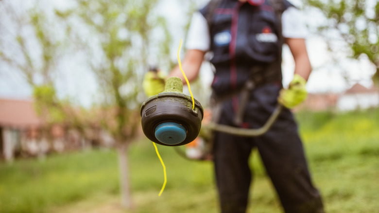 Person holding weed whacker 