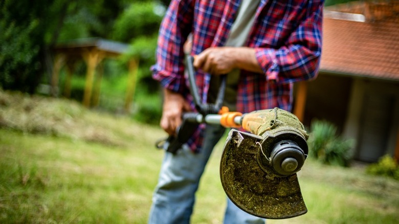 Man holding weed trimmer 