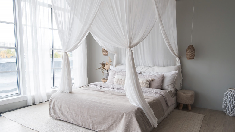 bed with white canopy curtains