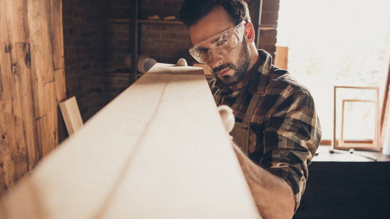 Person checking wood piece