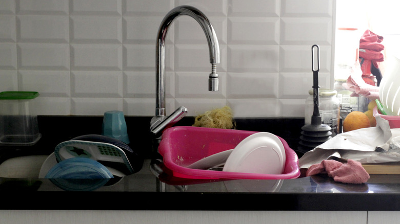 Pile of dirty dishes in sink