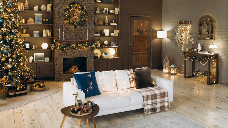 A living room with dark brown walls and Christmas decorations