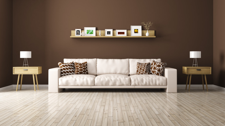 A chocolate brown wall behind a sofa in a living room