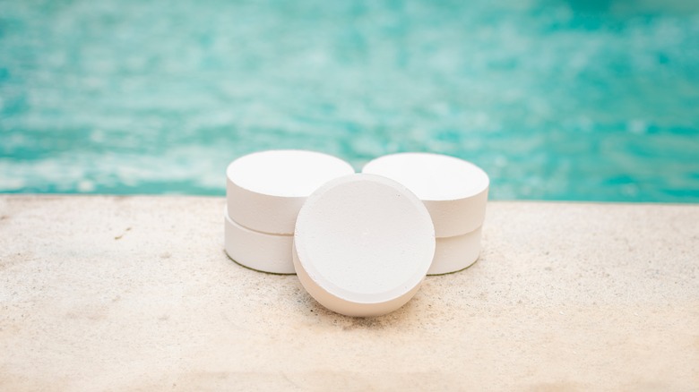 Close-up of shock tablets in front of pool