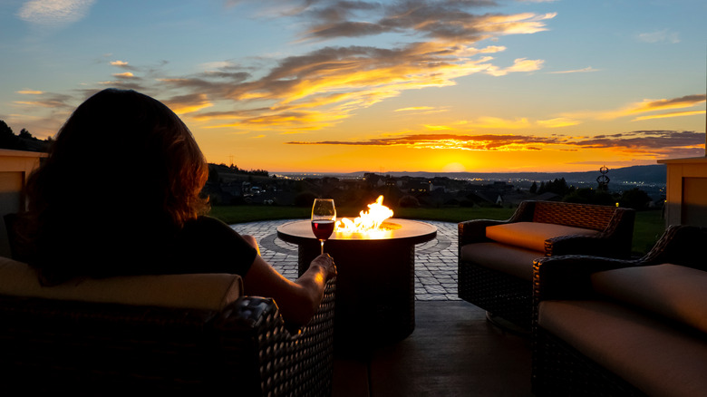 Woman with wine watching sunset