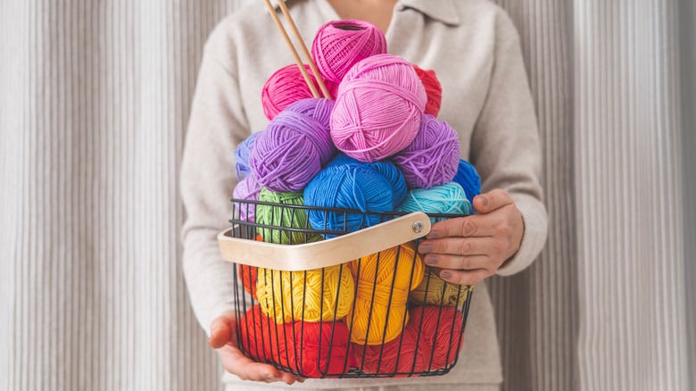 person holding basket of yarn