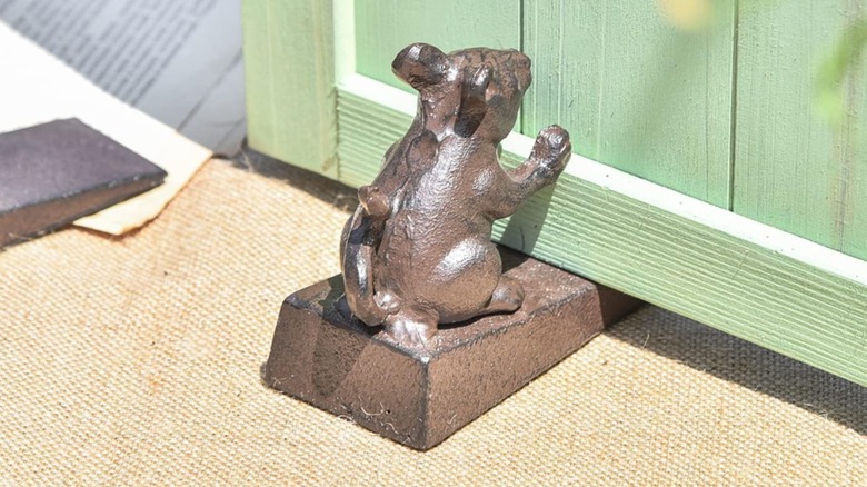 brass mice doorstop holding green door