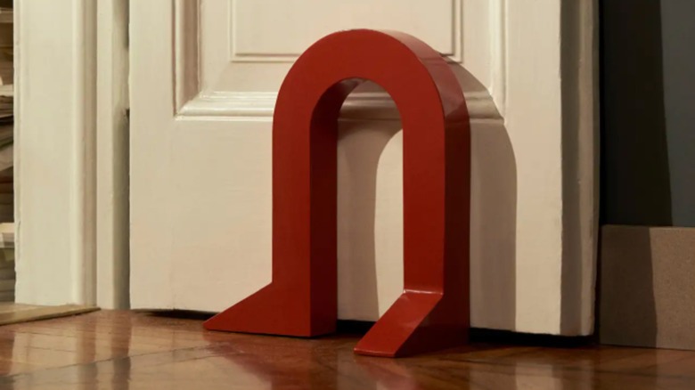 Red magnet doorstop in front of white door