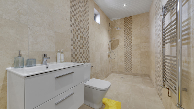 Wet room with vanity, walk-in shower, towel radiator, overhead lighting