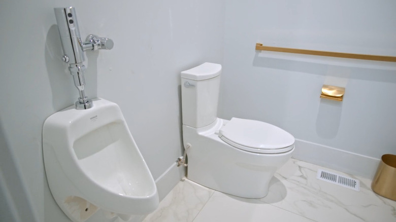 A urinal next to a toilet in a bathroom on Rock the Block